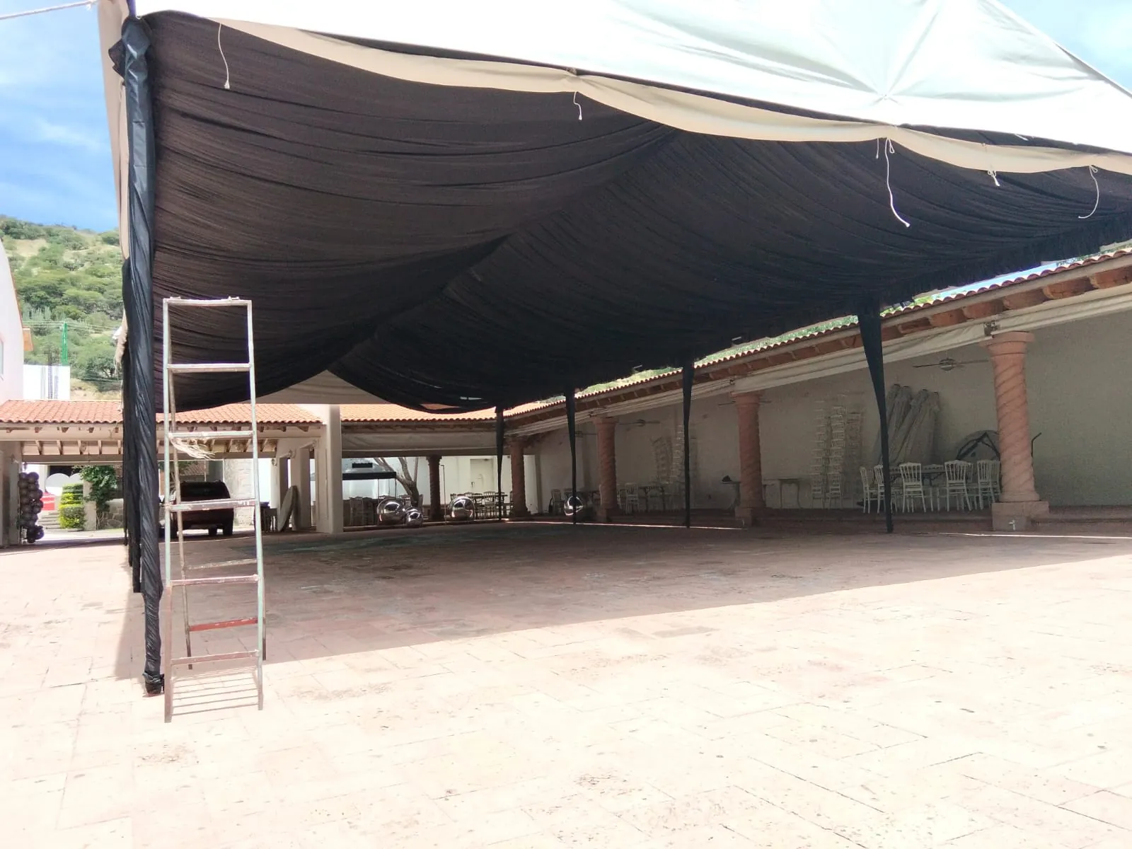 Carpa con drapeado negro cubriendo la terraza de un salón de eventos